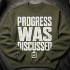 Green sweatshirt with distressed white text "PROGRESS WAS DISCUSSED".