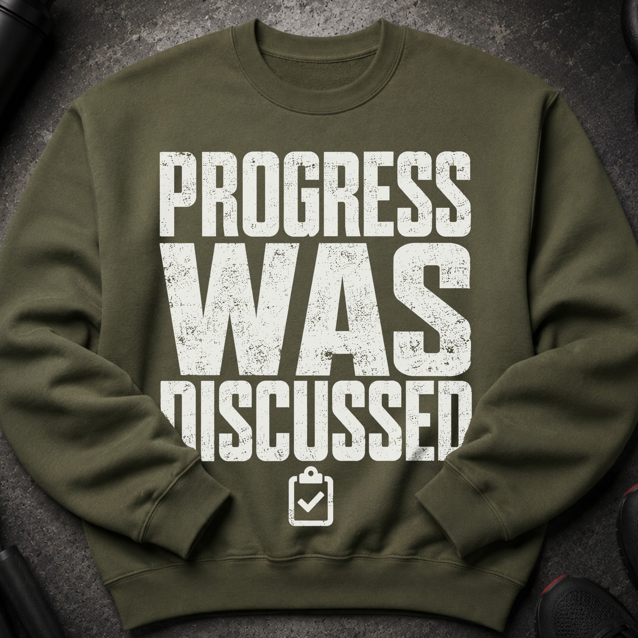 Green sweatshirt with distressed white text "PROGRESS WAS DISCUSSED".