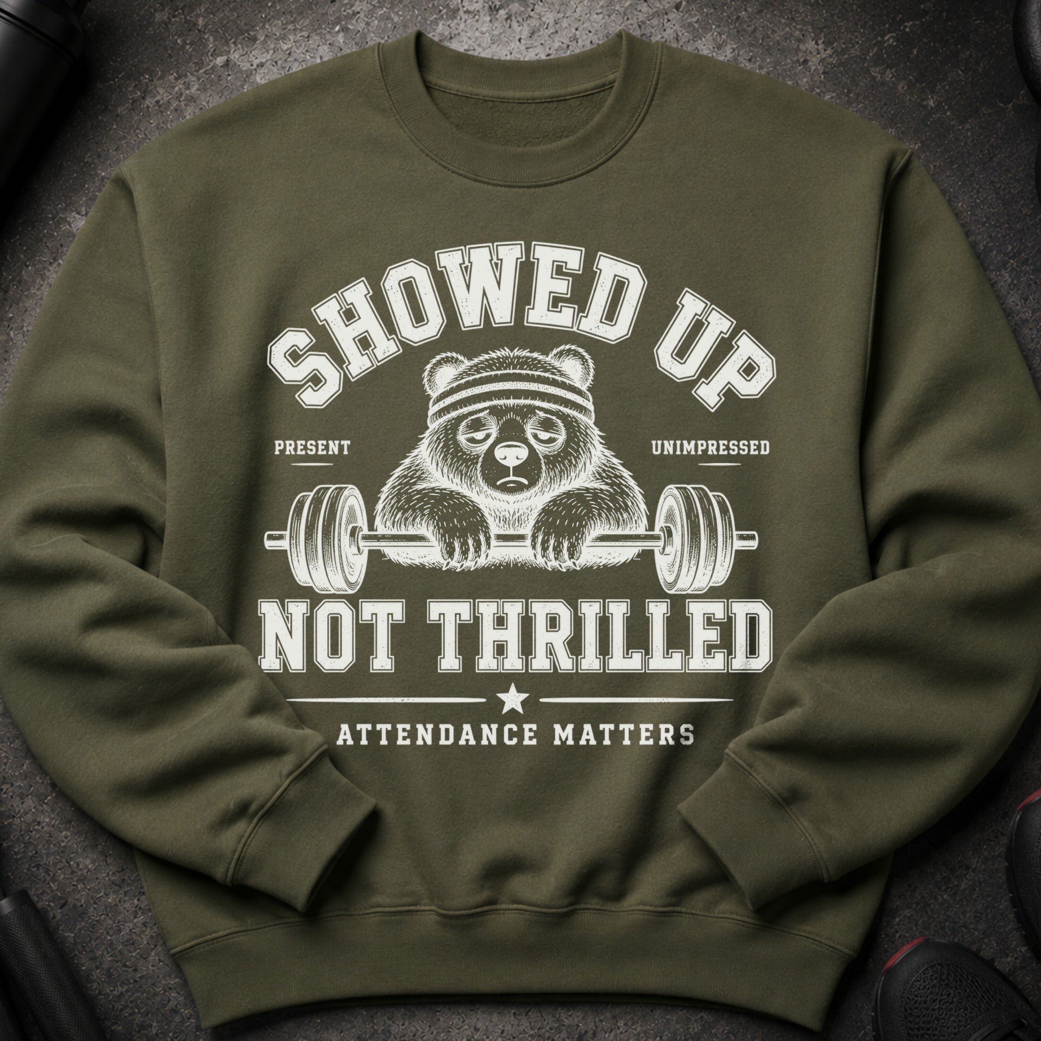 Green sweatshirt with graphic of unenthusiastic panda holding barbell, saying "Showed Up Not Thrilled Attendance Matters".