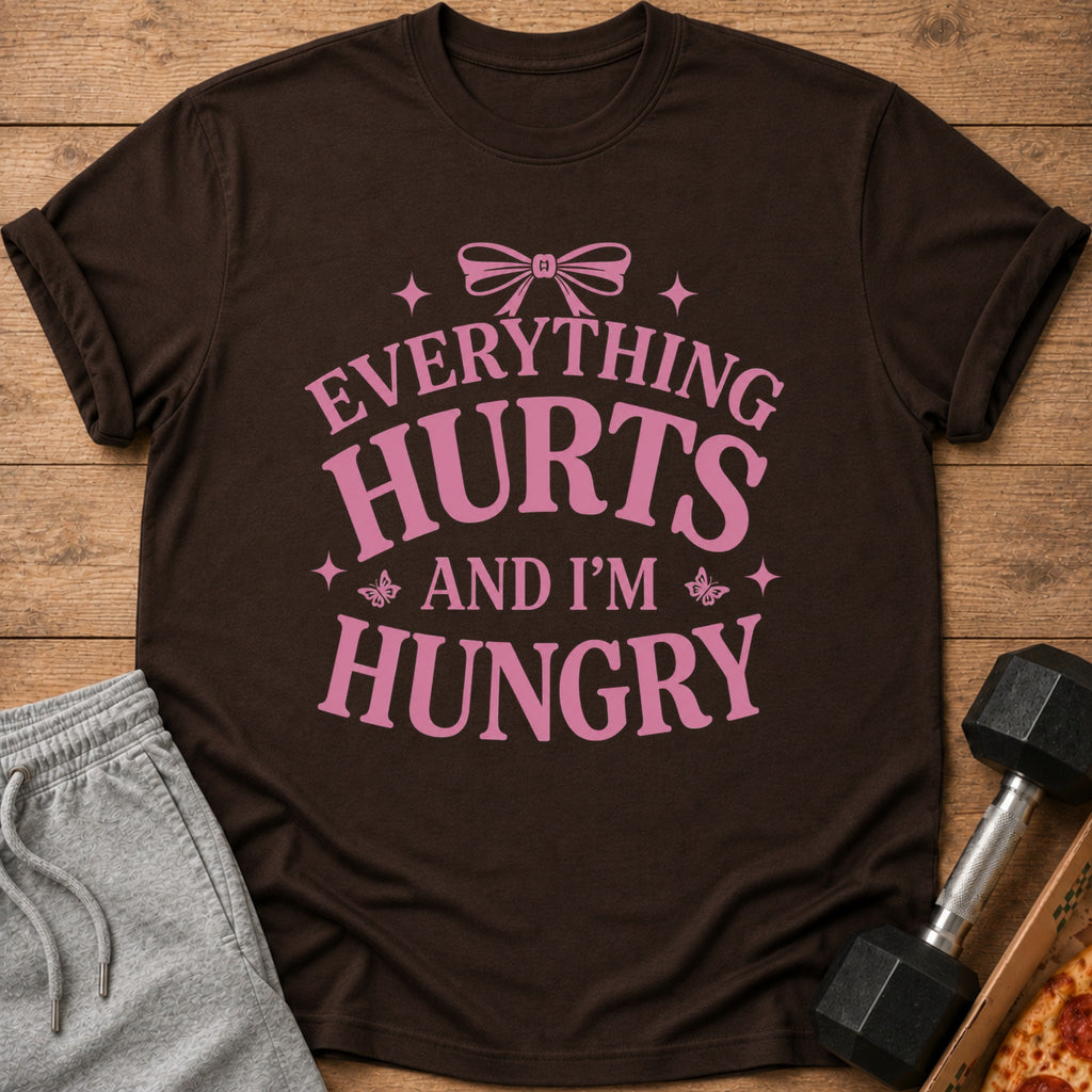 Brown t-shirt with pink text that says "Everything Hurts And I'm Hungry".