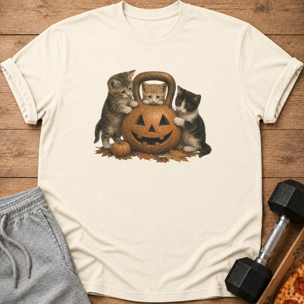 Three kittens around a jack-o'-lantern on an autumn-themed t-shirt.