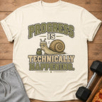 T-shirt with a snail lifting a weight and text "PROGRESS IS TECHNICALLY HAPPENING".