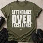 Olive green t-shirt with white distressed text reading "ATTENDANCE OVER EXCELLENCE"