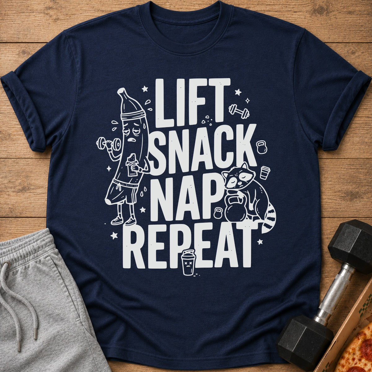 Navy t-shirt with "Lift Snack Nap Repeat" text, cartoon banana, and raccoon.