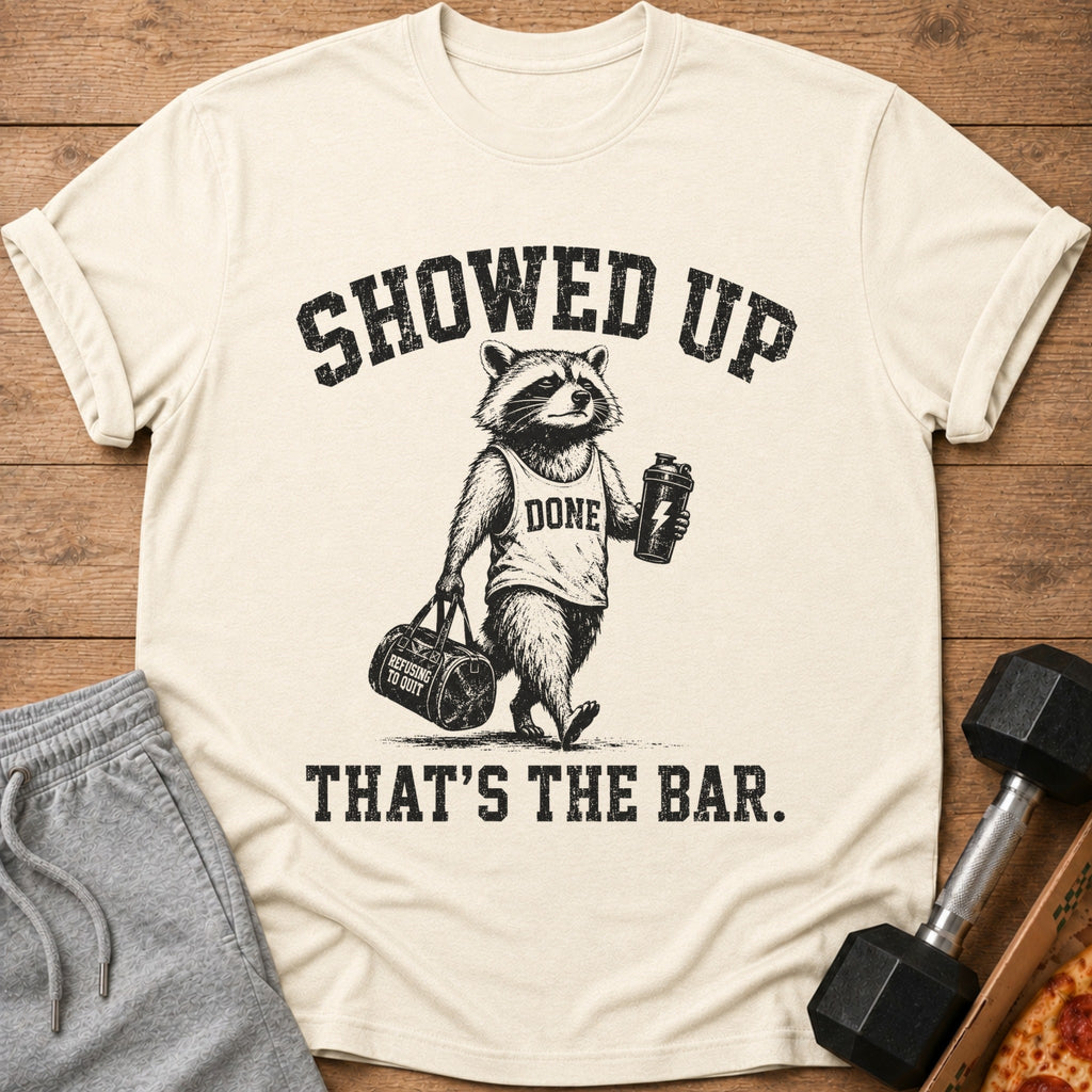 Raccoon wearing "DONE" shirt holding gym bag and shaker with text "SHOWED UP THAT'S THE BAR."