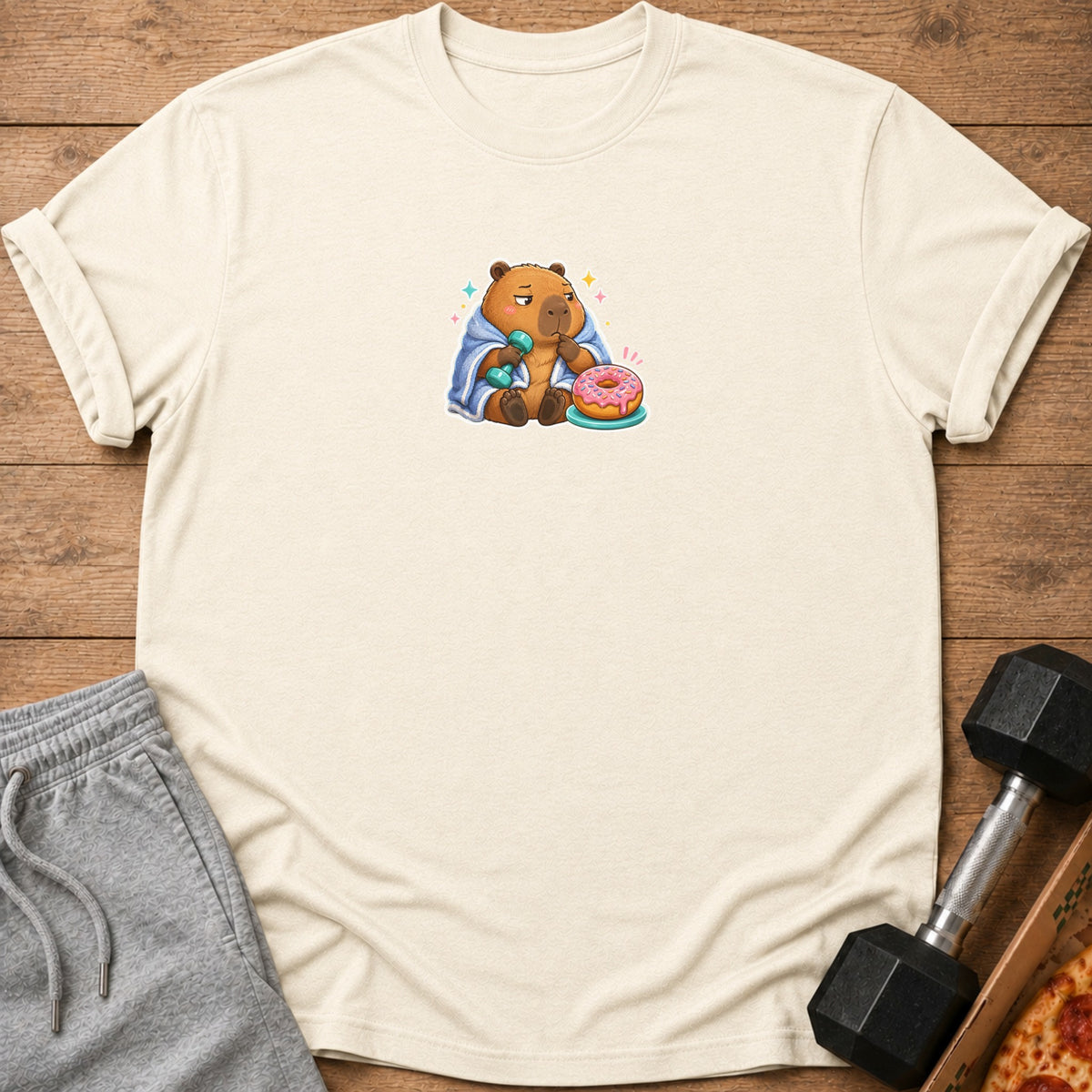 Capybara wearing blanket, holding dumbbell, with donut.