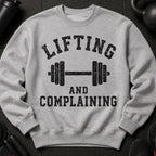 Grey sweatshirt with bold black text: "LIFTING AND COMPLAINING" above a barbell.