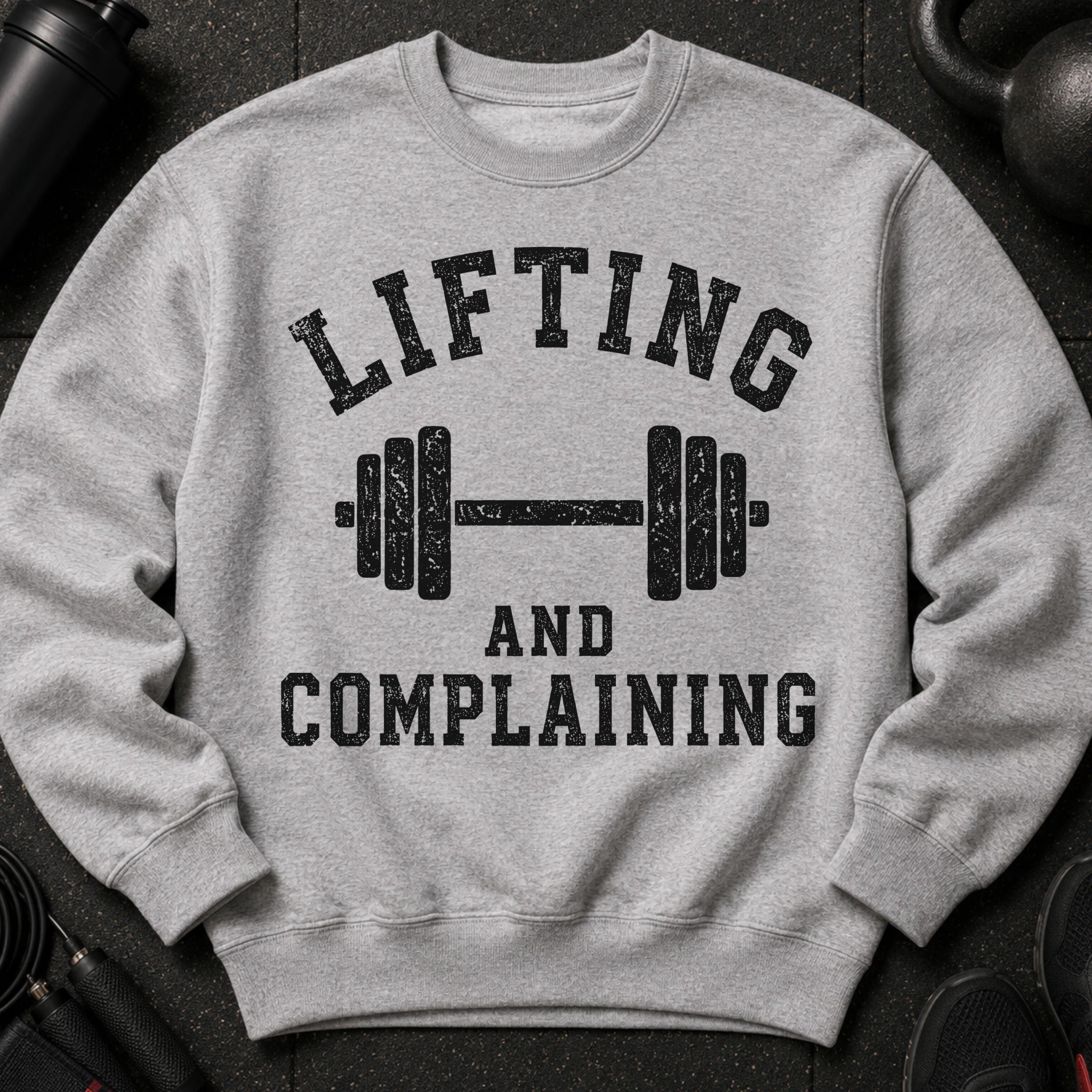 Grey sweatshirt with bold black text: "LIFTING AND COMPLAINING" above a barbell.