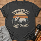 Dark grey t-shirt with a vintage graphic of a panda and text reading "Showed Up Still Counts."