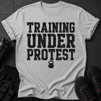 Grey t-shirt with black distressed text "TRAINING UNDER PROTEST" and a kettlebell graphic.