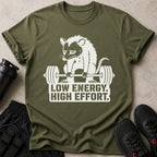 Olive green t-shirt with white graphic of a opossum lifting weights and text "LOW ENERGY. HIGH EFFORT."