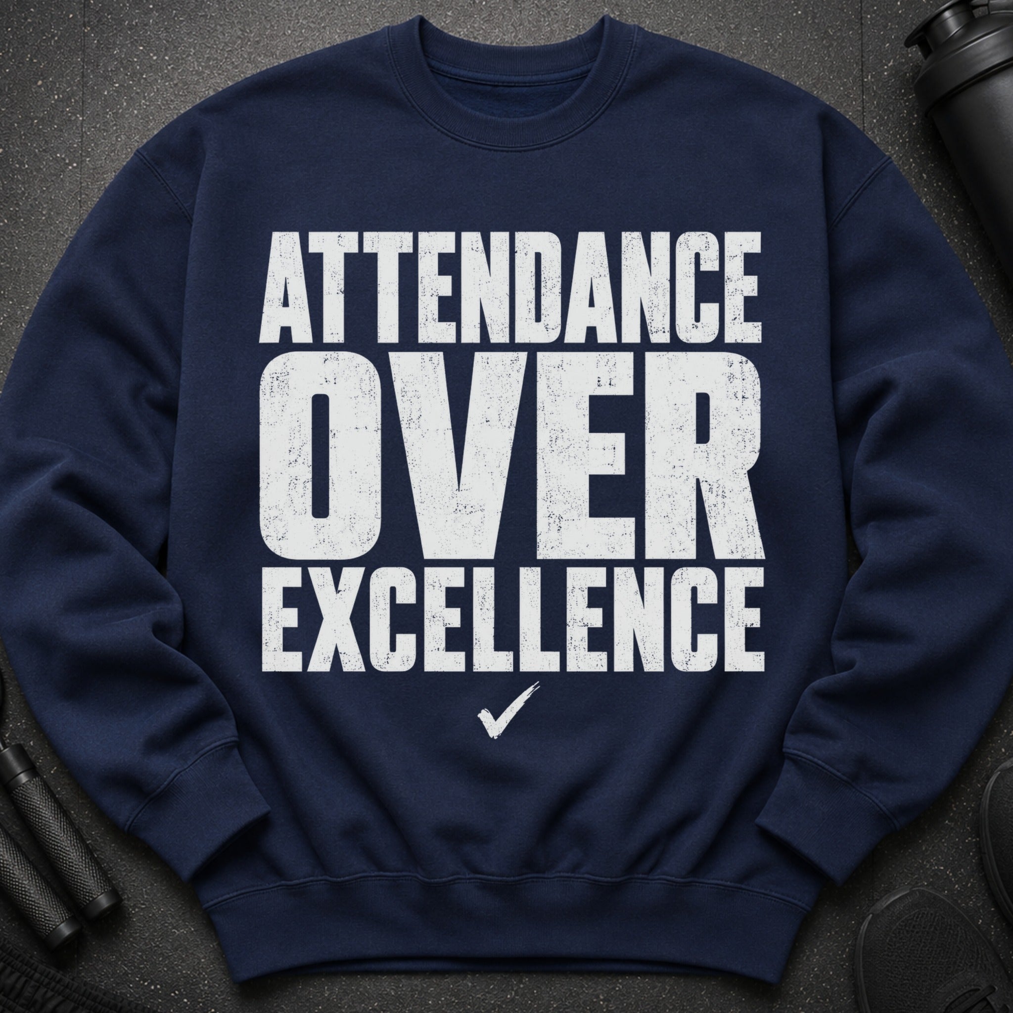 Navy sweatshirt with white text: "ATTENDANCE OVER EXCELLENCE" and a checkmark.