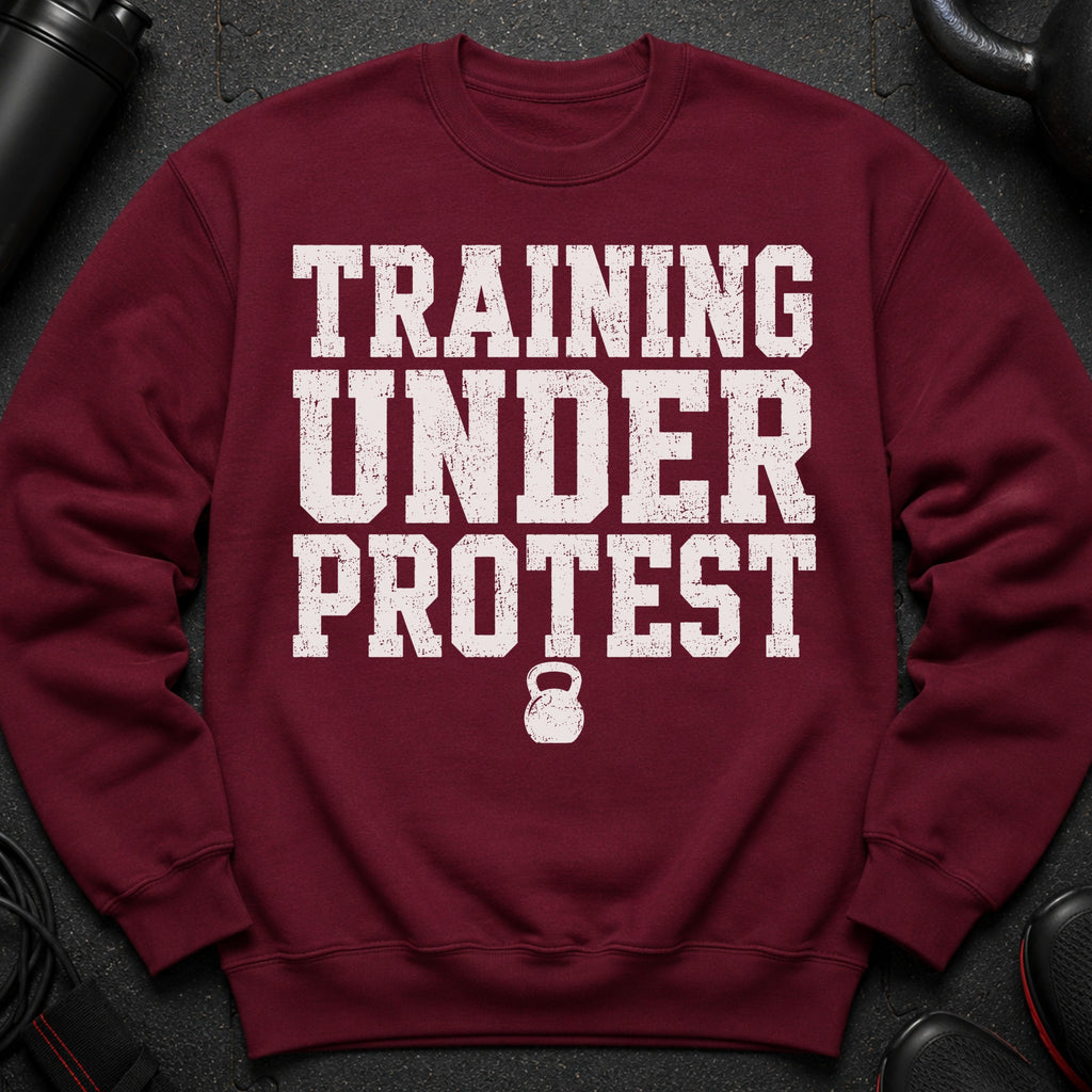 Maroon sweatshirt with "TRAINING UNDER PROTEST" and kettlebell graphic.