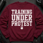 Maroon sweatshirt with "TRAINING UNDER PROTEST" and kettlebell graphic.