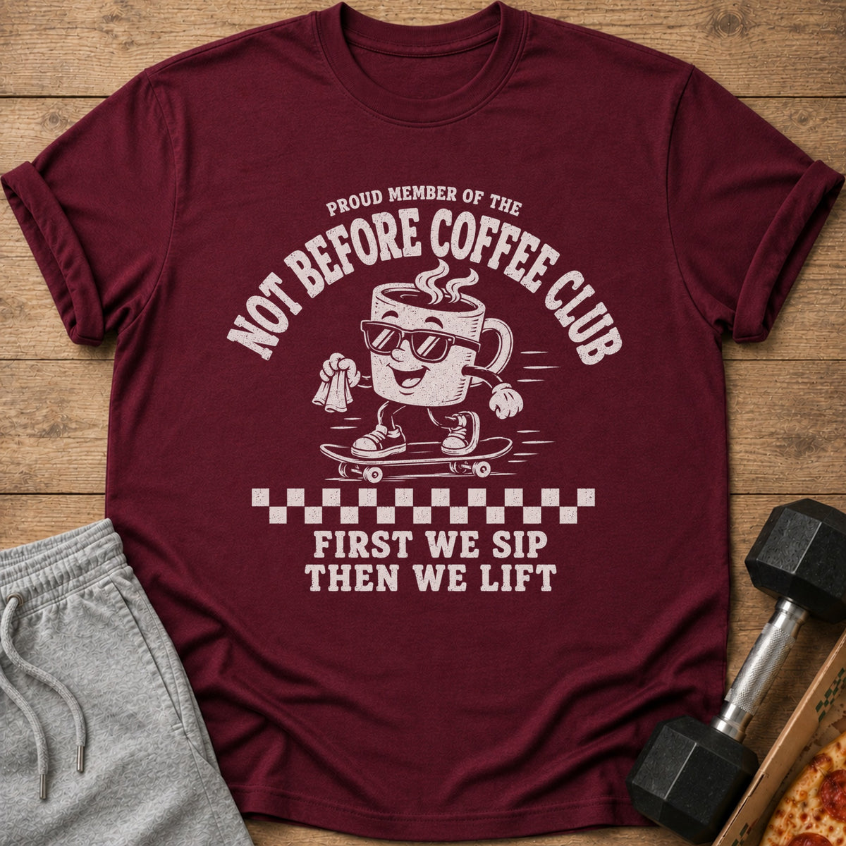 Maroon t-shirt with "Proud Member of the Not Before Coffee Club" and skating coffee cup graphic.