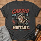 T-shirt graphic: raccoon on treadmill with text "Cardio Was A Mistake".