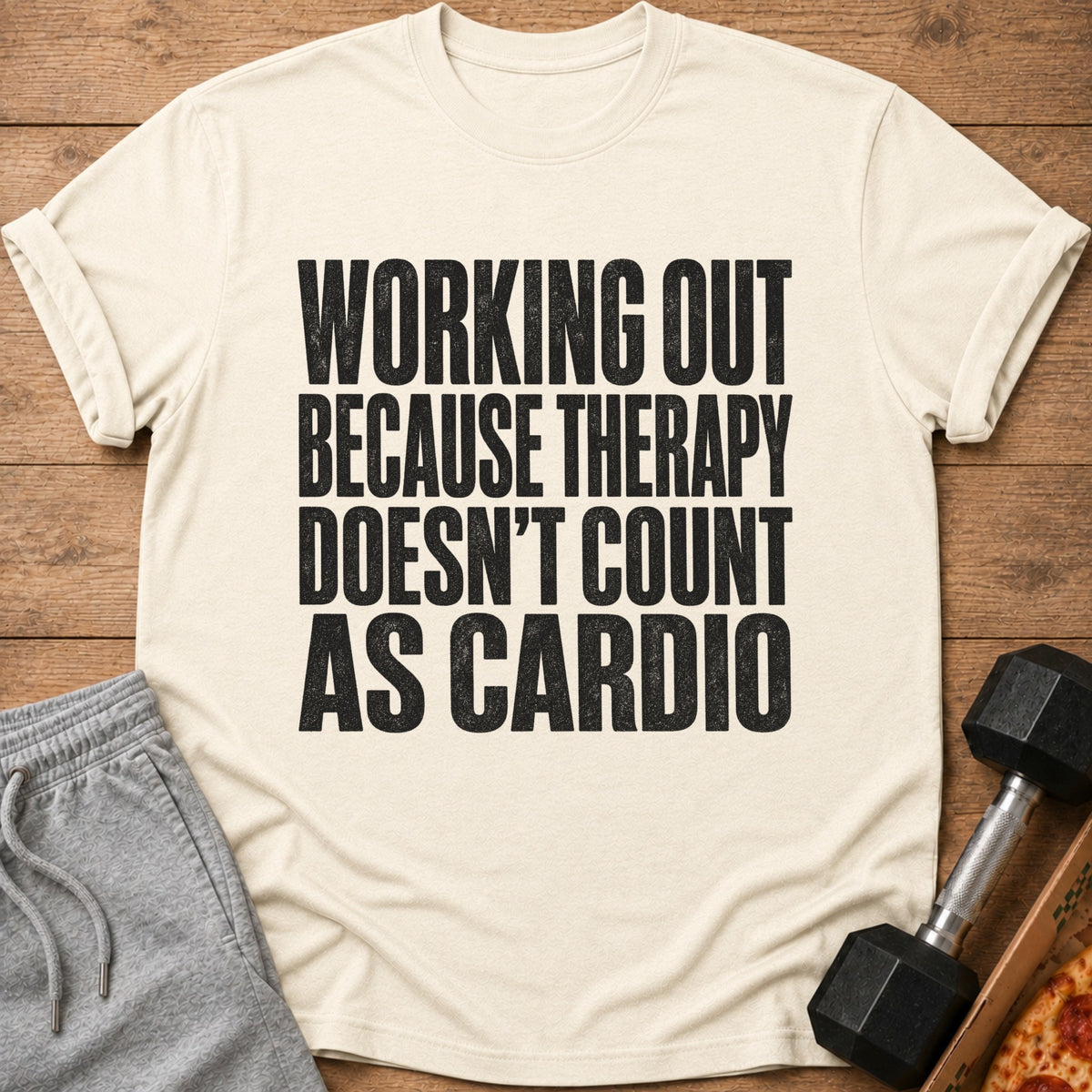 Cream t-shirt with black text: "WORKING OUT BECAUSE THERAPY DOESN'T COUNT AS CARDIO".