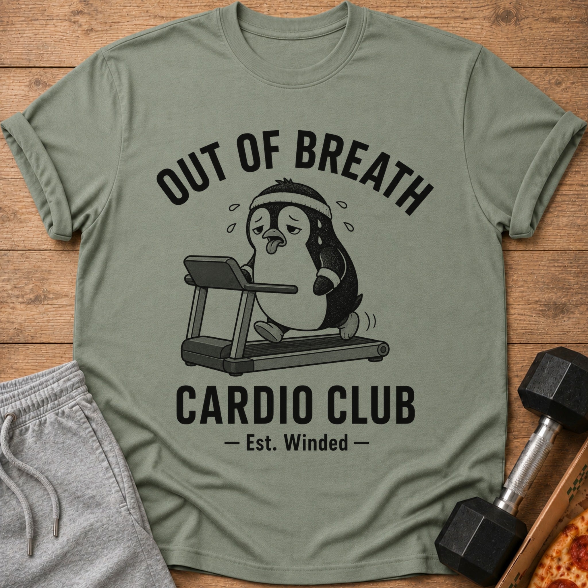 Olive green t-shirt with "OUT OF BREATH CARDIO CLUB - Est. Winded -" text and a penguin on a treadmill.