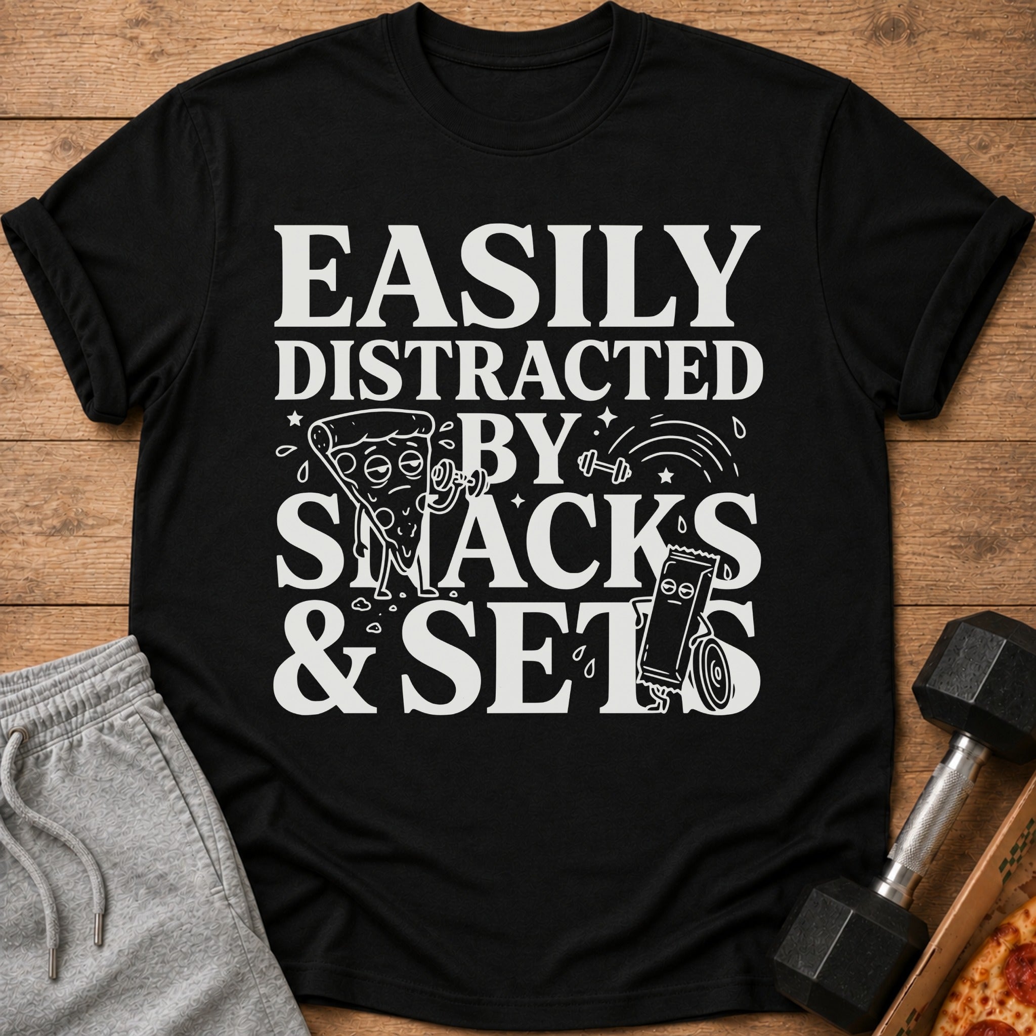 Black t-shirt with "Easily Distracted By Snacks & Sets" text and illustrations.