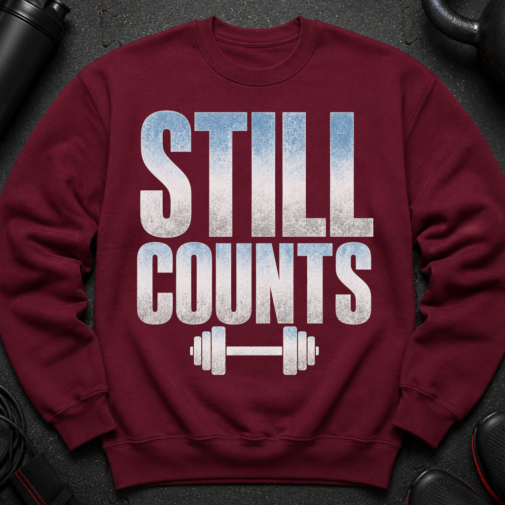 Maroon sweatshirt with "STILL COUNTS" text and dumbbell graphic.