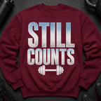 Maroon sweatshirt with "STILL COUNTS" text and dumbbell graphic.