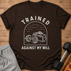 Brown t-shirt with white text "TRAINED AGAINST MY WILL" and gym graphics.