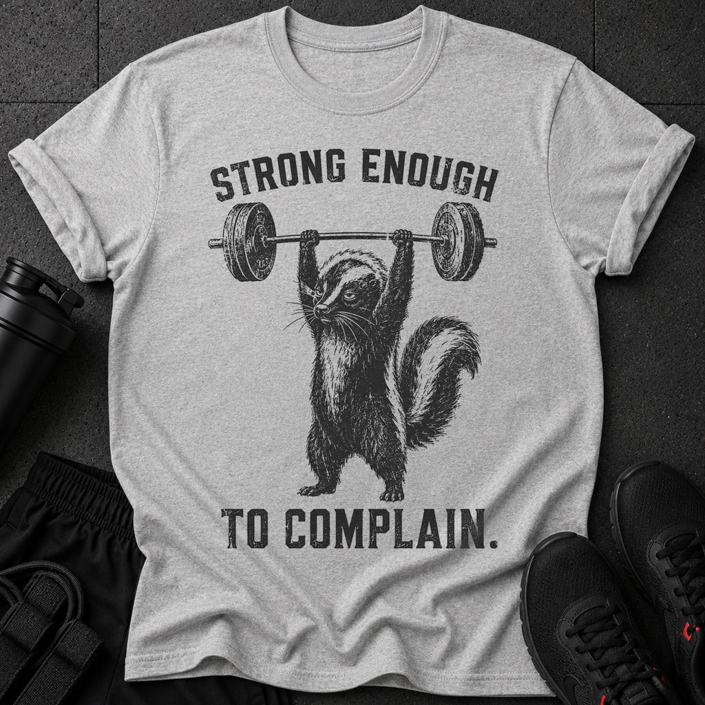 Gray t-shirt with skunk lifting barbell and text "STRONG ENOUGH TO COMPLAIN."