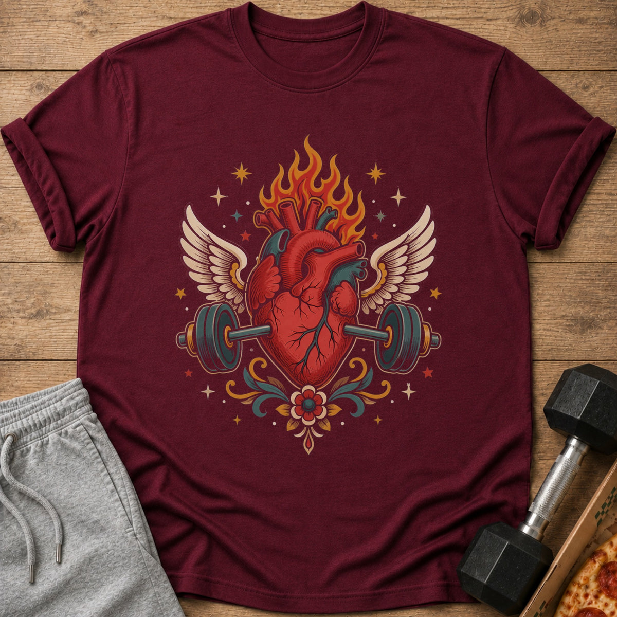 Burgundy t-shirt with anatomical heart, wings, barbell, and flames graphic.