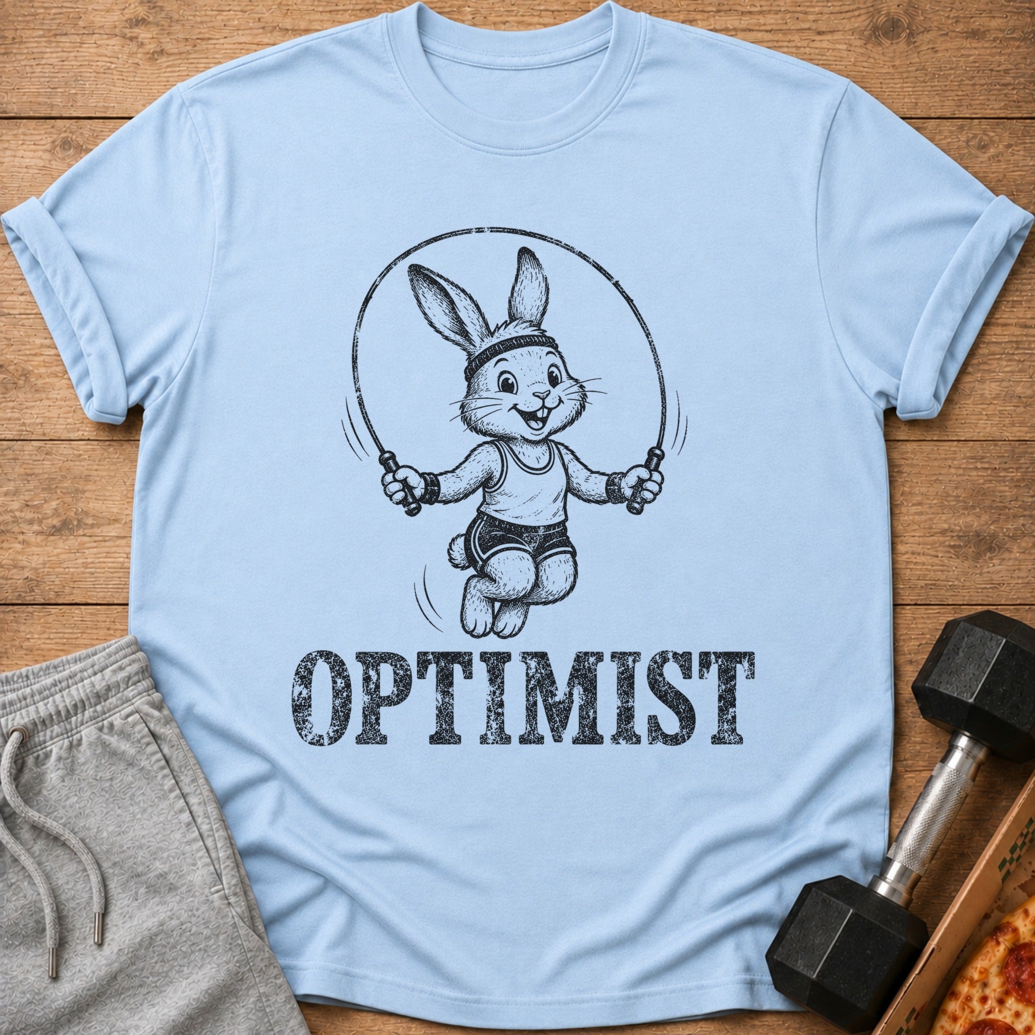 Light blue t-shirt with a cartoon rabbit jumping rope and the word OPTIMIST.