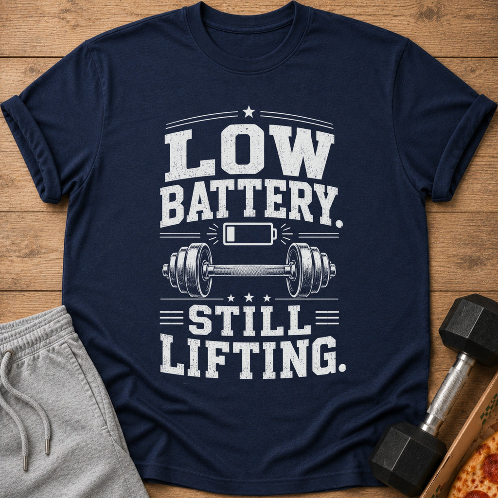 Navy t-shirt with text "LOW BATTERY. STILL LIFTING." and barbell graphic.