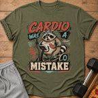 T-shirt graphic: raccoon on elliptical, text "Cardio Was A Mistake".