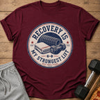 Maroon t-shirt with circular graphic: "RECOVERY IS MY STRONGEST LIFT REST REPS COUNT."