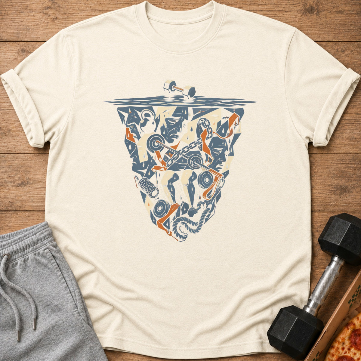 Cream t-shirt with abstract shield graphic of gym equipment and faces.