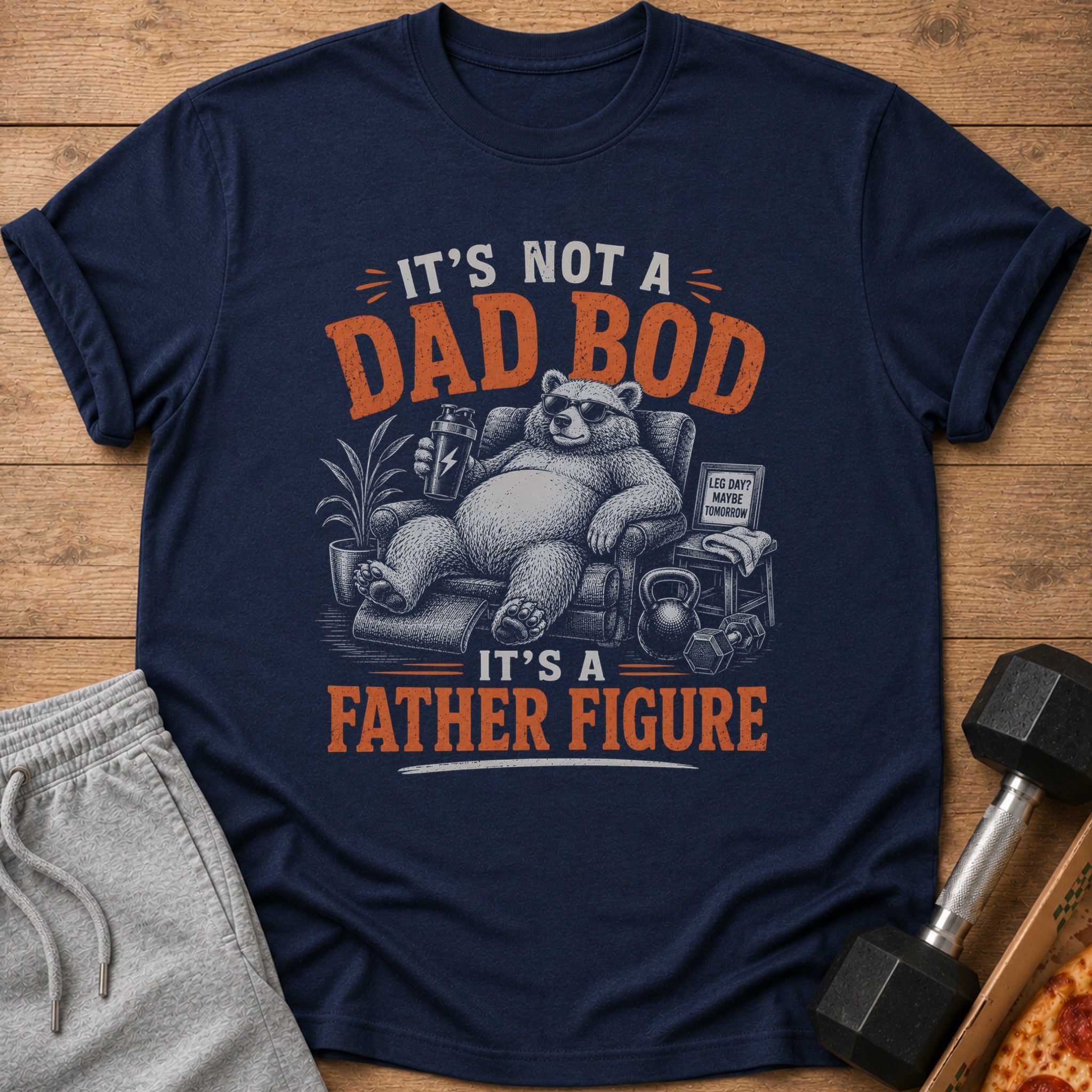 "It's not a dad bod, it's a father figure" printed on a navy t-shirt with a bear graphic.