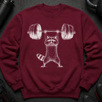 Maroon sweatshirt with white illustration of a raccoon lifting a barbell.