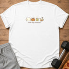 White t-shirt with "rest day season" text and icons of a pillow, pumpkin, kettlebell, and coffee.