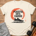 Light cream t-shirt with "PEACEFUL UNTIL CARDIO" graphic and a running shoe.