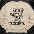 Light brown sweatshirt with a distressed graphic of a pizza slice lifting a dumbbell and the text "THIS COUNTS."