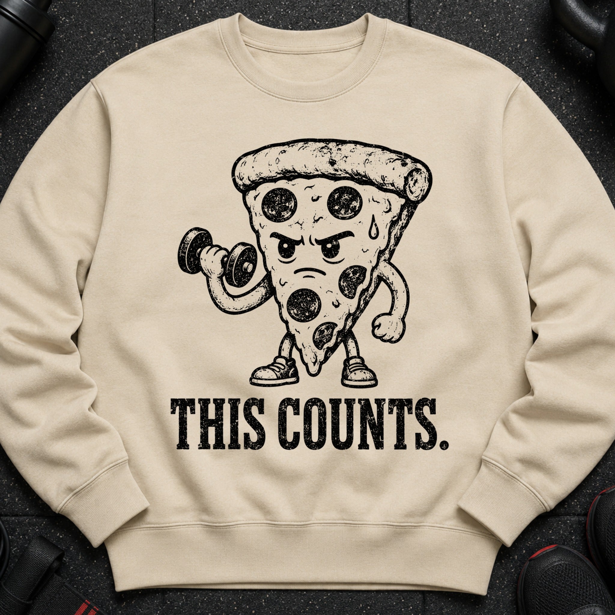 Light brown sweatshirt with a distressed graphic of a pizza slice lifting a dumbbell and the text "THIS COUNTS."