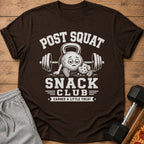 Brown t-shirt with "POST SQUAT SNACK CLUB" text and a kettlebell holding a cookie.