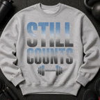 Gray sweatshirt with "STILL COUNTS" text and a dumbbell graphic.