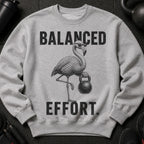 Grey sweatshirt with text "BALANCED EFFORT" and a flamingo lifting a kettlebell.