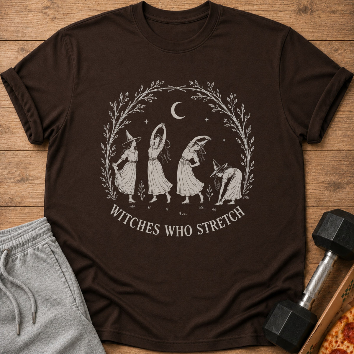 Brown t-shirt with "Witches Who Stretch" graphic of witches doing yoga poses.
