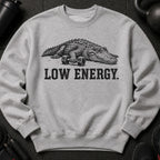 Alligator with dumbbells, text "LOW ENERGY" on grey sweatshirt.