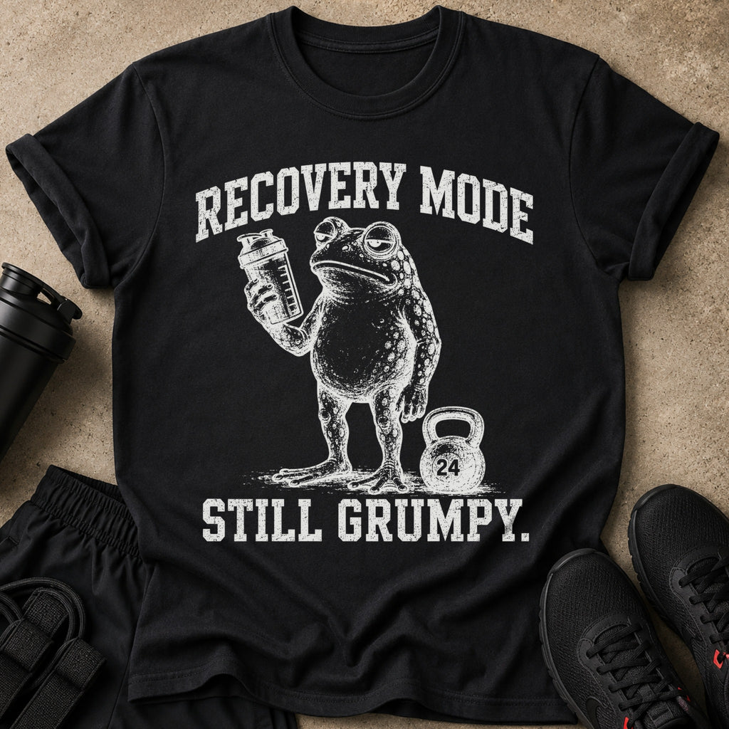 Black t-shirt with distressed graphic of a frog holding a shaker bottle and a kettlebell. Text reads "RECOVERY MODE STILL GRUMPY."