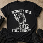 Black t-shirt with distressed graphic of a frog holding a shaker bottle and a kettlebell. Text reads "RECOVERY MODE STILL GRUMPY."
