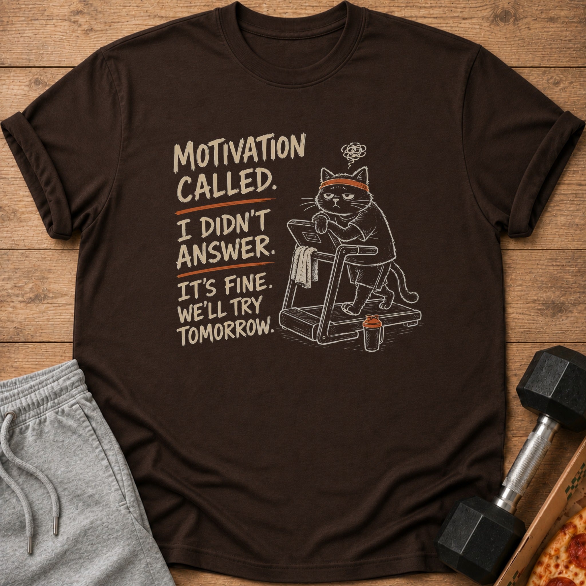 Dark brown t-shirt with a cat on a treadmill and text "Motivation called. I didn't answer."