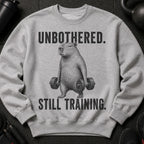 Gray sweatshirt with a capybara holding dumbbells, text reads "UNBOTHERED. STILL TRAINING."