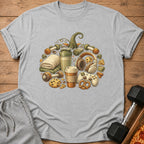 T-shirt with a pumpkin design made of dumbbells, headphones, coffee cup, and cookies.