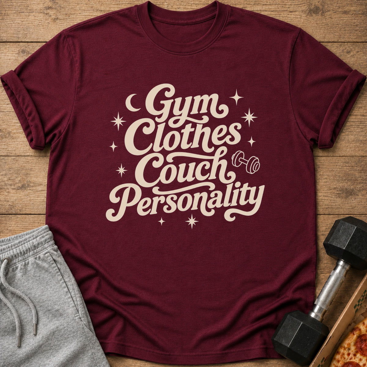 Maroon t-shirt with cream text "Gym Clothes Couch Personality" and graphics.